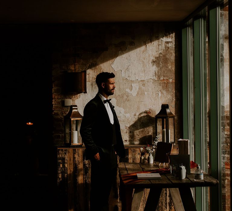 Groom in three piece suit stand out overlooking the view at rustic venue in Nottingham