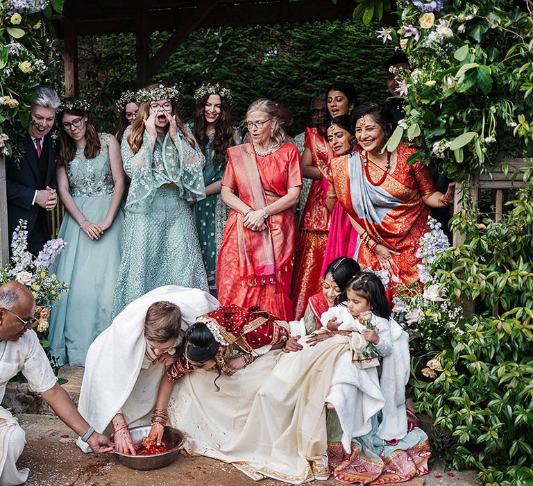 Guests celebrate as the bride and groom take part in customs for traditional Indian weddings