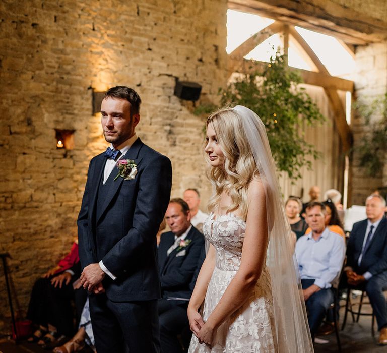 Bride and groom stand at the altar as they take part in their ceremony 