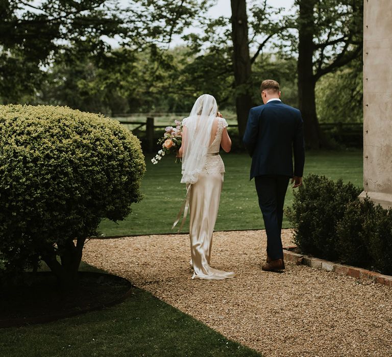 Bride & groom walk through Aswarby Rectory grounds on their wedding day after ceremony 