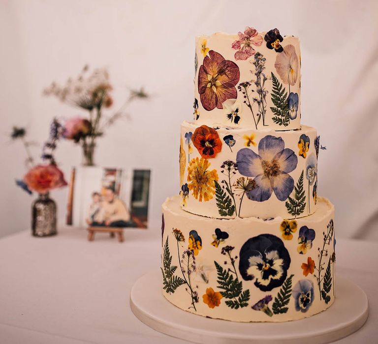 A three tier frosted pressed flower wedding cake for a botanical wedding 