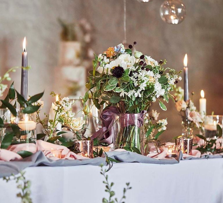 Romantic lowers, taper candles and votives wedding table decor for rustic East Riddlesden Hall wedding reception 