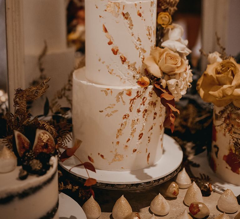 Two-tier white frosted wedding cake finished with personalised cake topper and dried floral decor