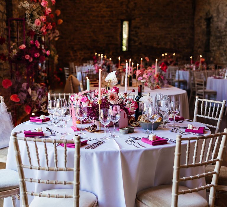 Eco candle wedding favours, bright pink fabric napkins and bright floral centrepiece for modern tablescape look