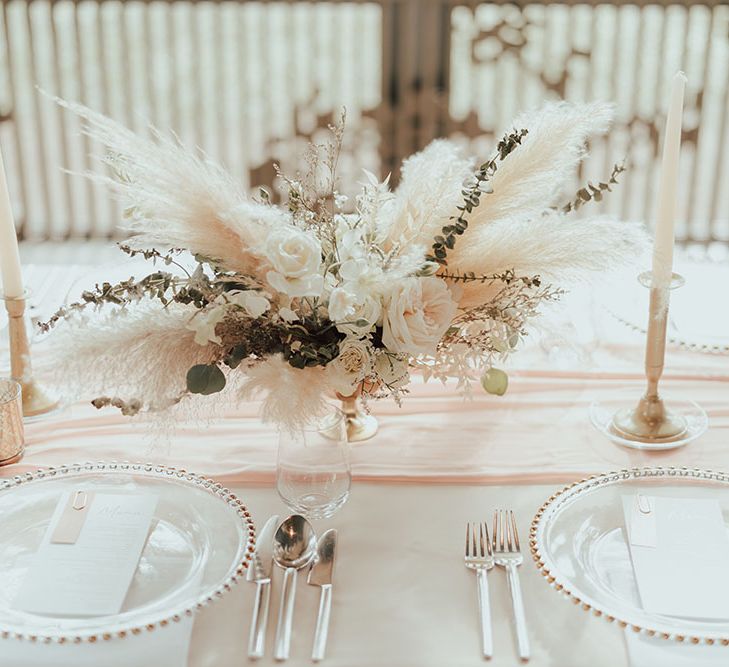 Dried floral pampas grass centrepiece on pastel pink fabric table runner 