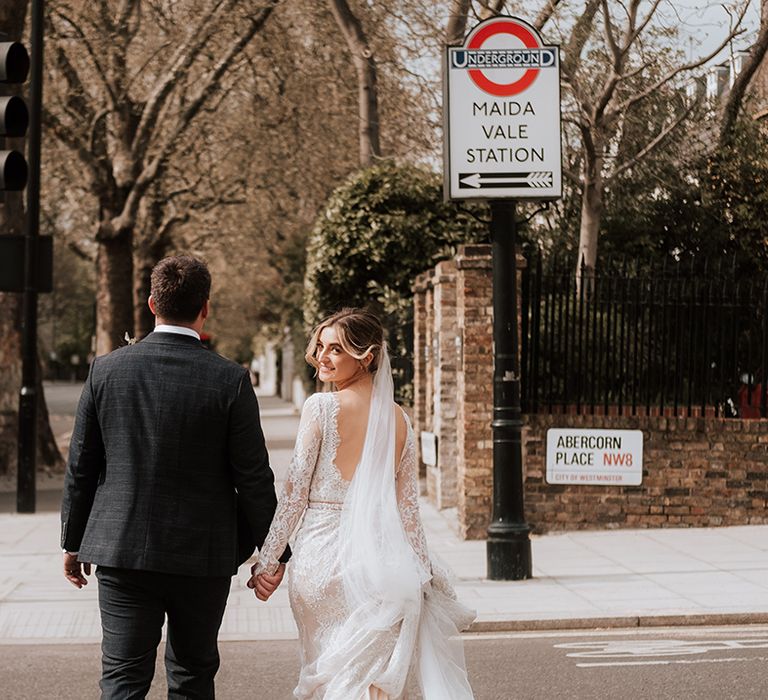 Bride wears low back wedding dress complete with cathedral veil 