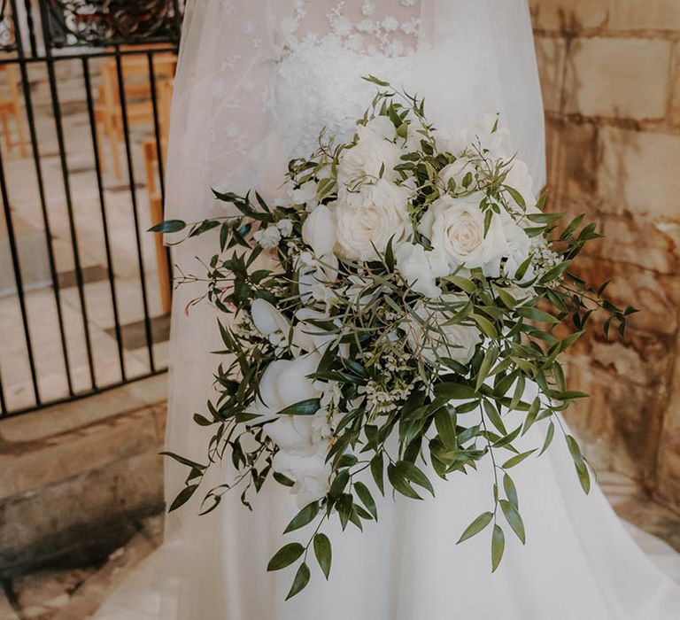 Bride holding a white rose bouquet of flowers 