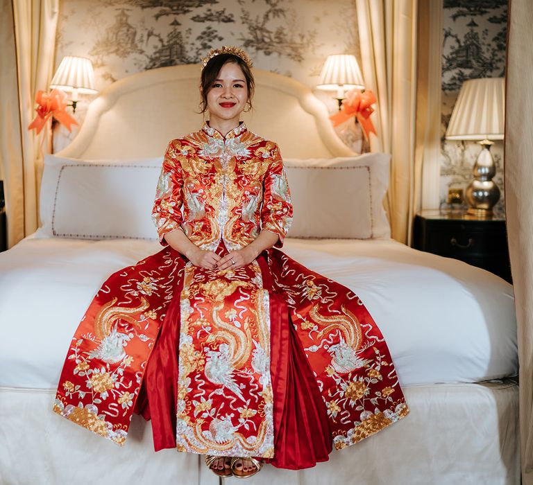 East Asian bride wears beautifully embroidered wedding dress with red and gold colouring 