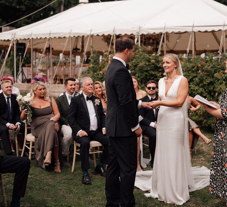 The bride and groom look into each other's eyes for their outdoor wedding ceremony 