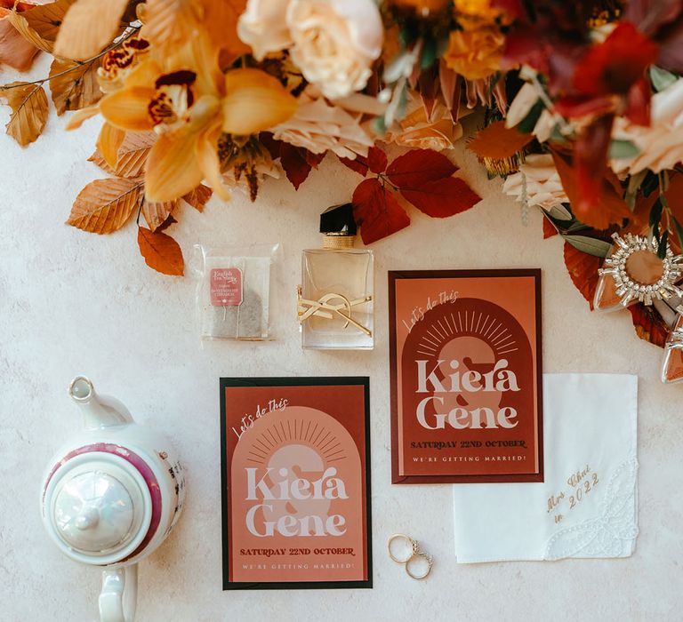 Burnt orange stationery with modern styling beside wedding flowers  