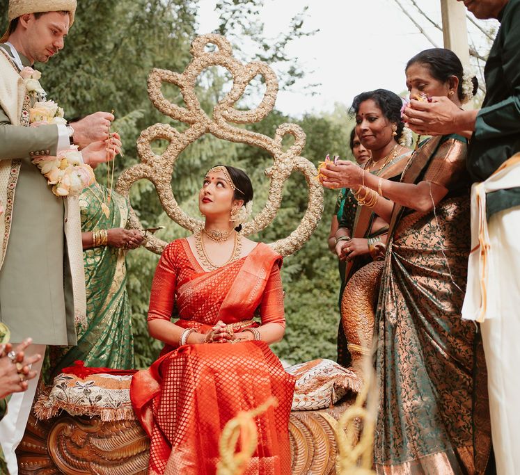 Hindu marriage ceremony under a mandal with bride in a red lehenga 