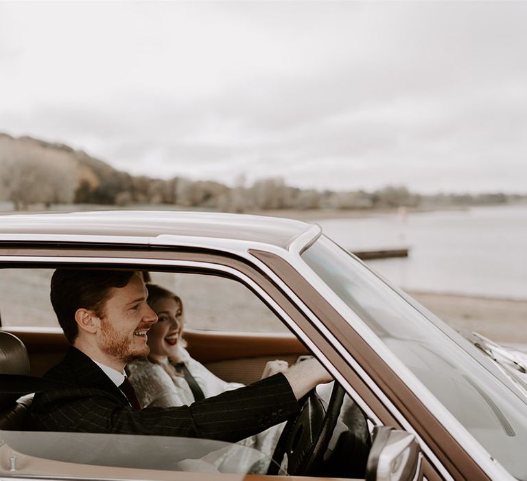 The groom drives the bride over to their wedding reception in brown Mercedes wedding car 