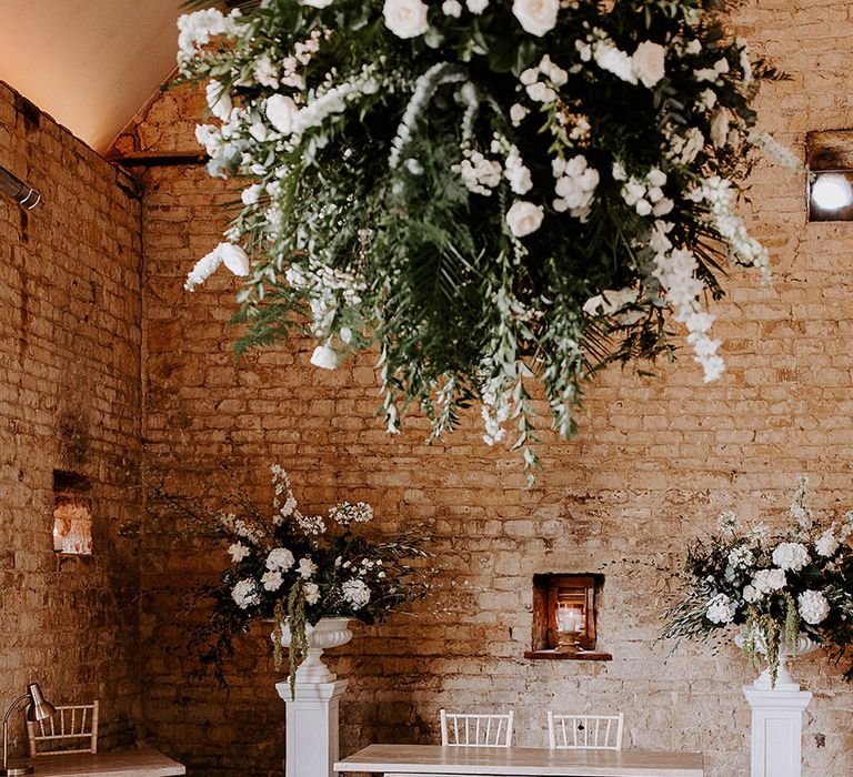 Lapstone Barn wedding in the Cotswolds with white wedding aisle and altar flowers with hanging arrangement 