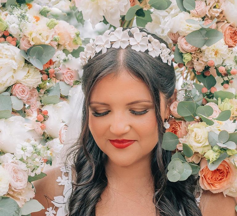 Bride wearing red lipstick and white floral head piece for the wedding day 