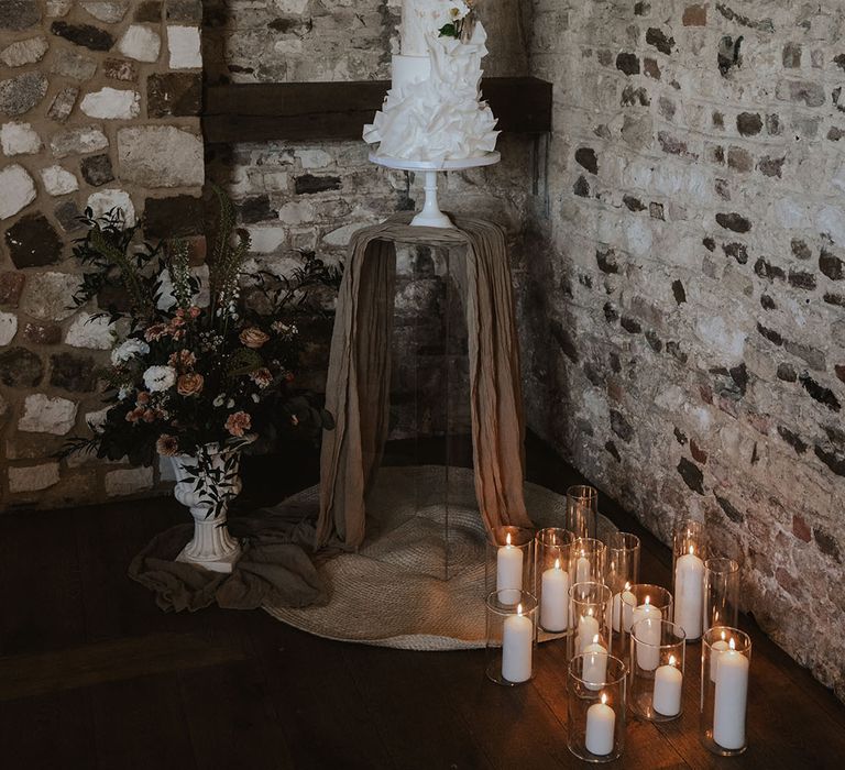 Three tier white wedding cake with textured ruffles that match the wedding dress 