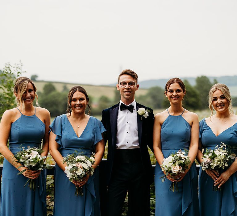 Dusky blue groomsmaid dresses with groom in blue tuxedo 