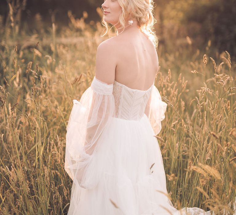 Bride in a strapless wedding dress with sheer sleeves