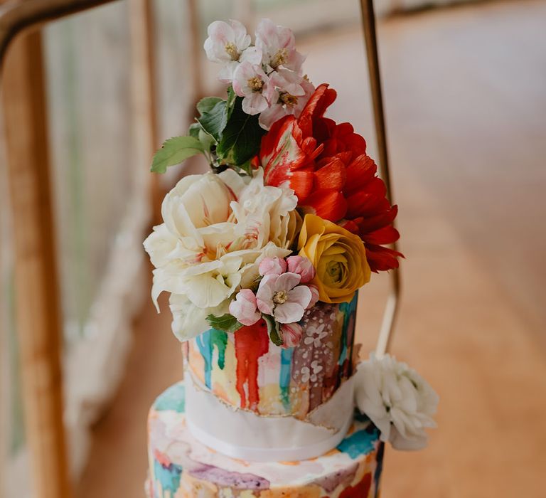 Three tier colourful marble wedding cake with flower decorations 