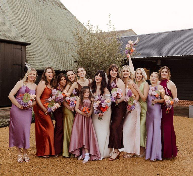 Bridal party wearing satin colourful mismatched bridesmaid dresses 