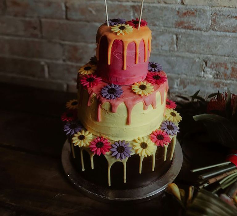 Three tier wedding cake with pink, orange and green icing with flowers 