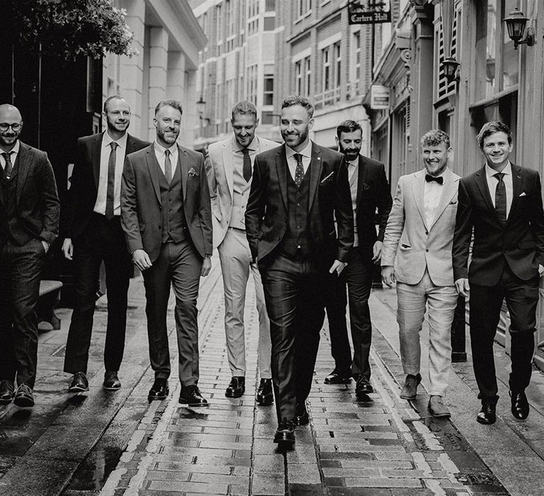 The groom and groomsmen walking the streets of London together before the wedding 