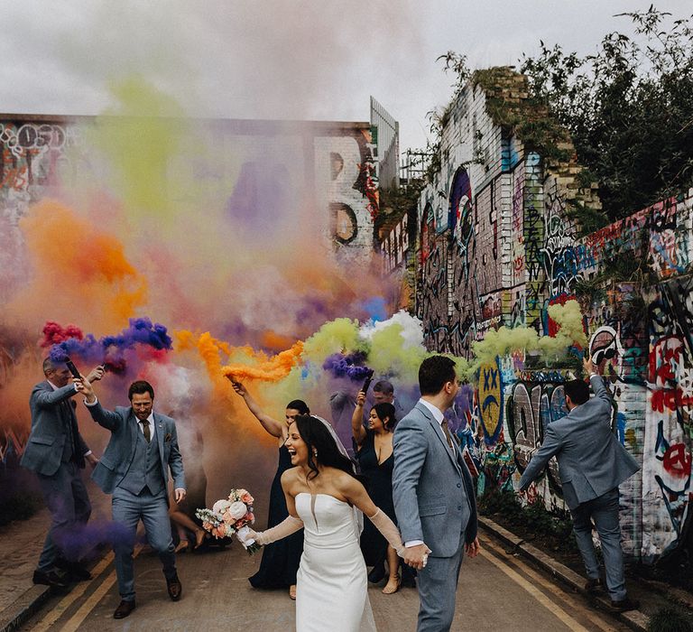 Urban city wedding with bright and colourful wedding smoke flares with the wedding party 