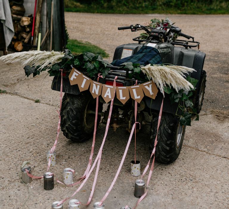 Quad bike with 'finally' bunting and tin can decor