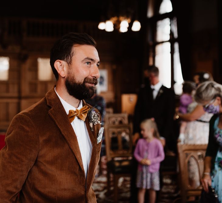 Groom in brown cord jacket and bow tie 