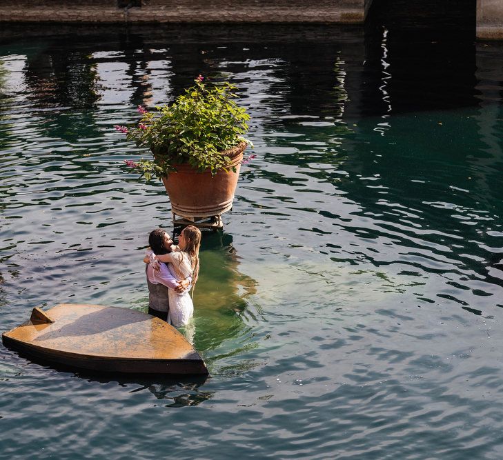 Bride and groom in the lake at The Lost Orangery