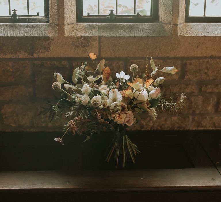 Autumn wedding bouquet with green, white and brown wedding flowers and foliage 