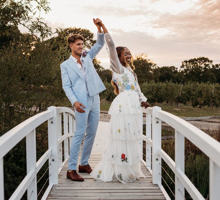 Bride in a tulle and flower wedding dress and groom in a pale blue suit