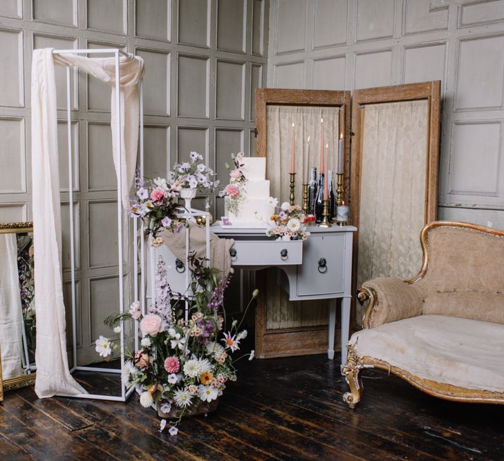 Ornate mirror decor with pastel wedding flowers and antique seating