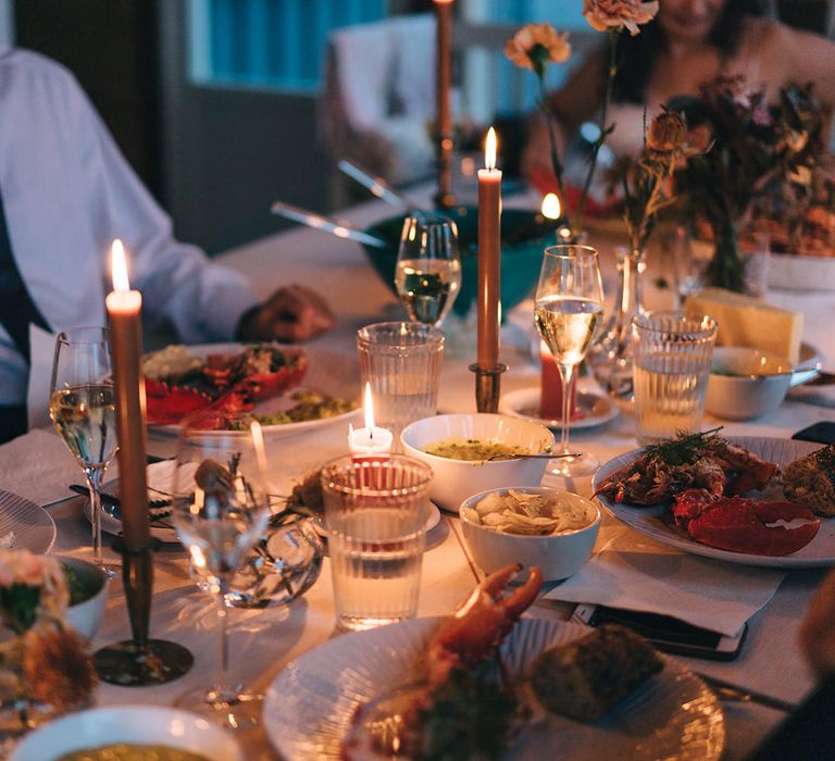 An intimate family meal with a table covered in plates, candles and small bowls