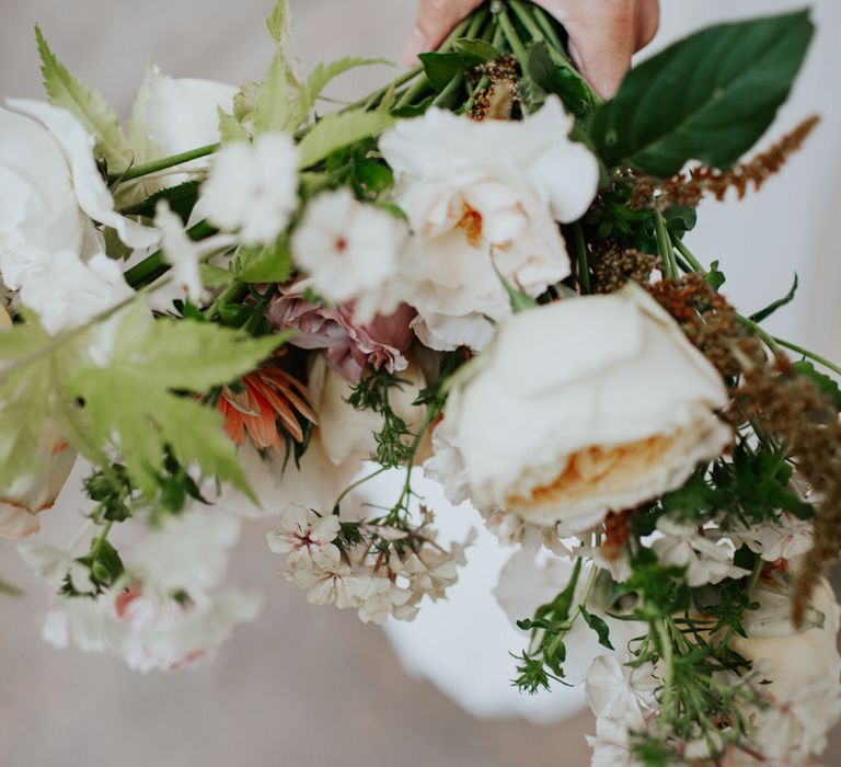 The bride's bouquet made up of fresh white and blush orange flowers