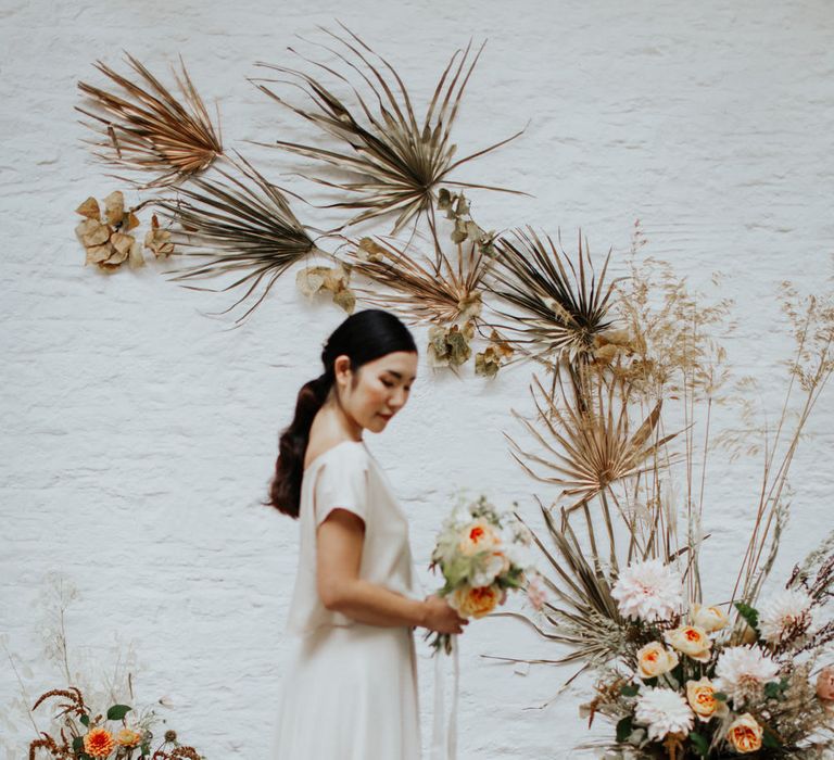 The bride wearing a relaxed wedding dress with slouchy top and a flowing skirt