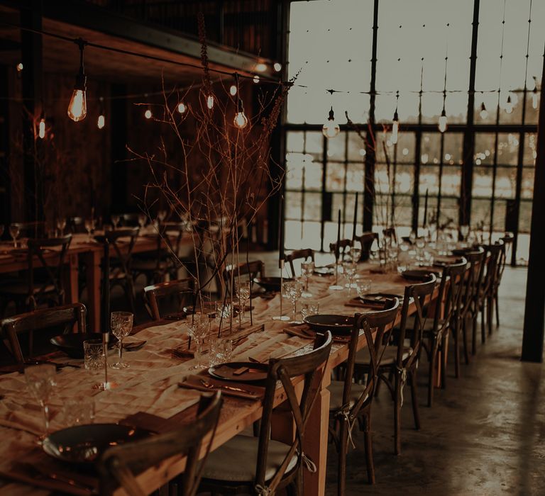 Hidden River Cabins reception inspiration with wooden table and chairs, minimalist dried flower arrangements and taper candles 