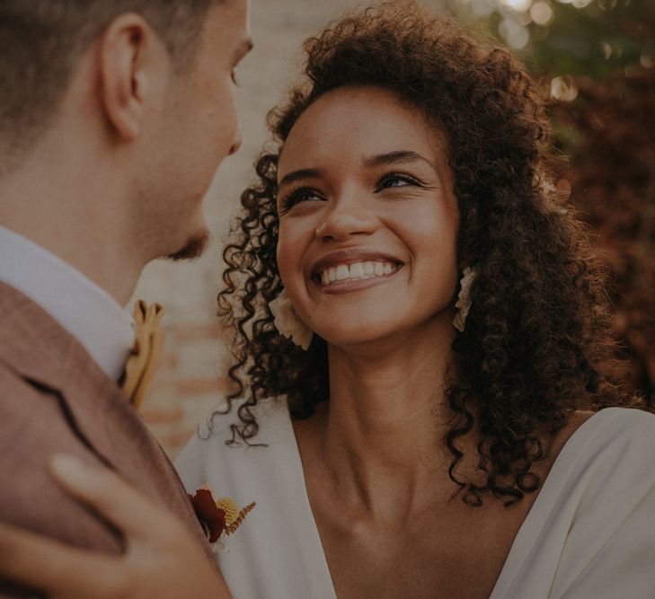 Beautiful black bride smiling with natural makeup up and curly hair 