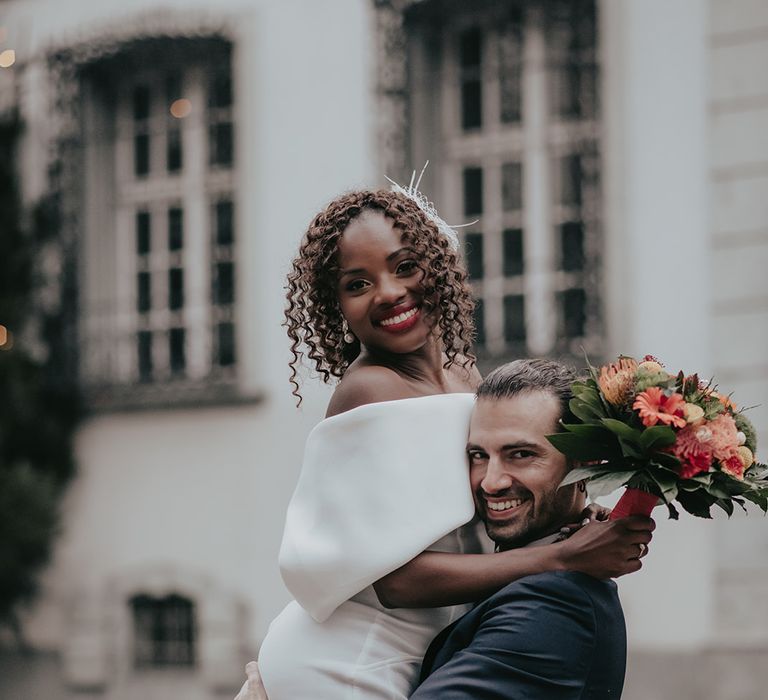 Groom lifts bride as they stand on the streets of Old Town 