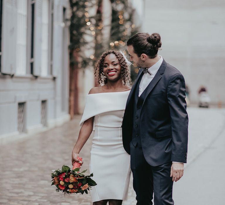 Bride & groom walk together as bride carries bouquet