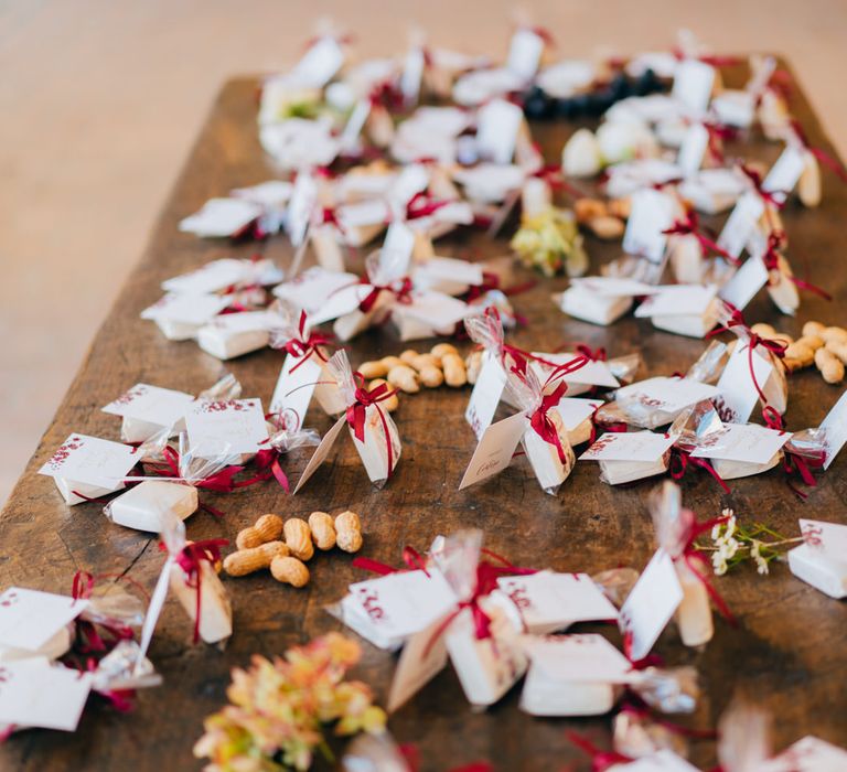 A table of marshmallow wedding favours tied with burgundy ribbon