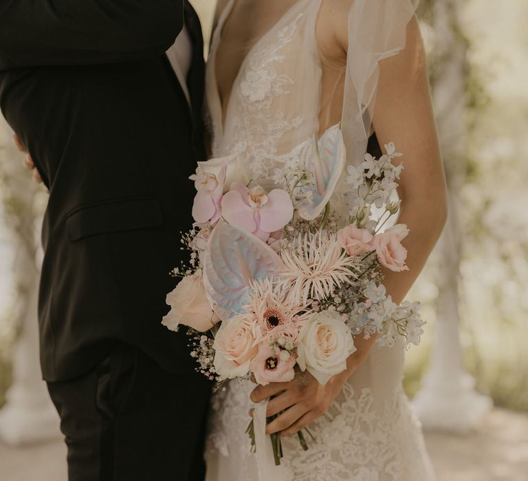 Pastel wedding bouquet with dahlias, orchids, iridescent anthuriums and roses 