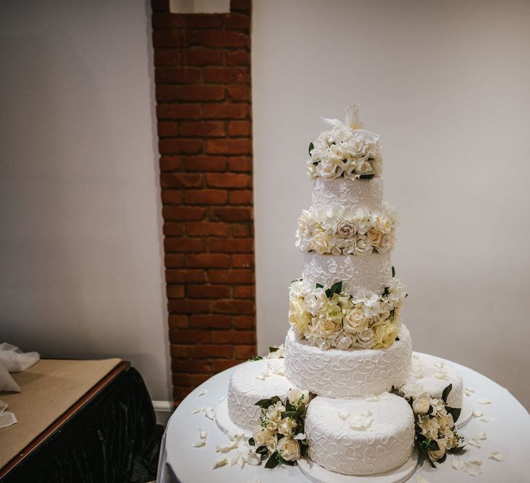 Three tier iced white wedding cake with white floral decor for Ethiopian wedding 