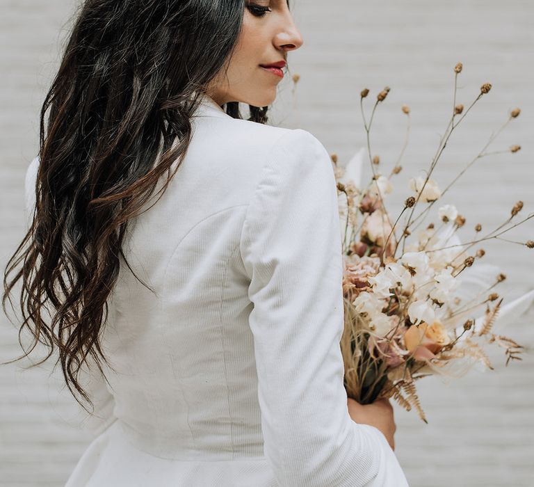 Bride wearing a tailored white blazer with long, loose flowing hairstyle for minimal all white wedding