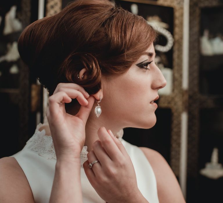 Bride with a vintage 1960s updo hairstyle, and 1960s inspired makeup with pearl earrings