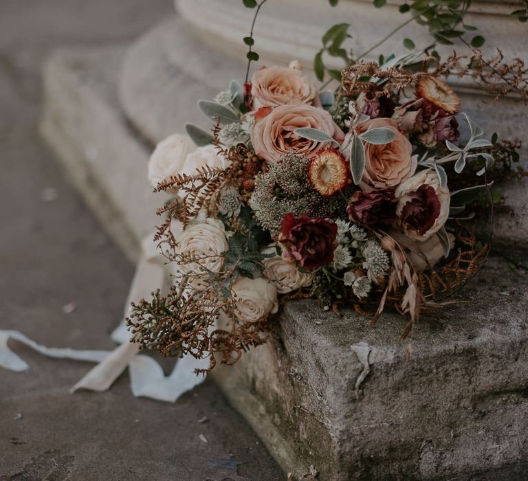 Rose and foliage bouquet lying sideways on stone step