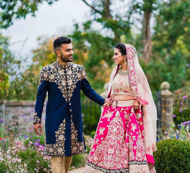 Hindu fusion wedding with pink bride dress and navy traditional outfit for groom