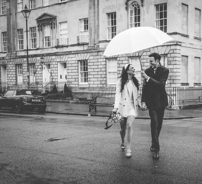 Bride and groom under ambarella - black and white wedding photography