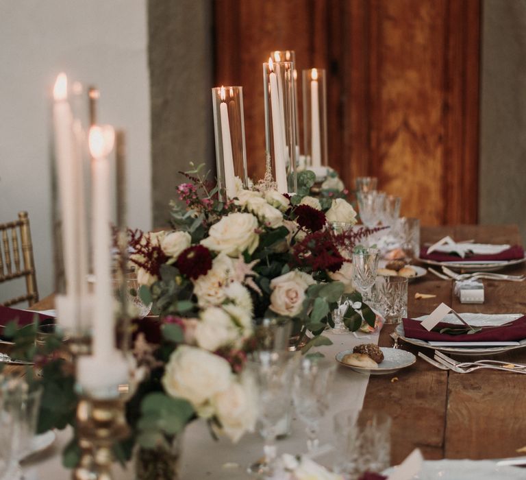 Rustic Italian table setting complete with candlelights and white table runner