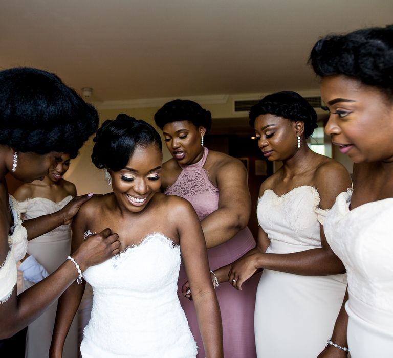 Bride gets ready on the morning of her wedding surrounded by her bridal party