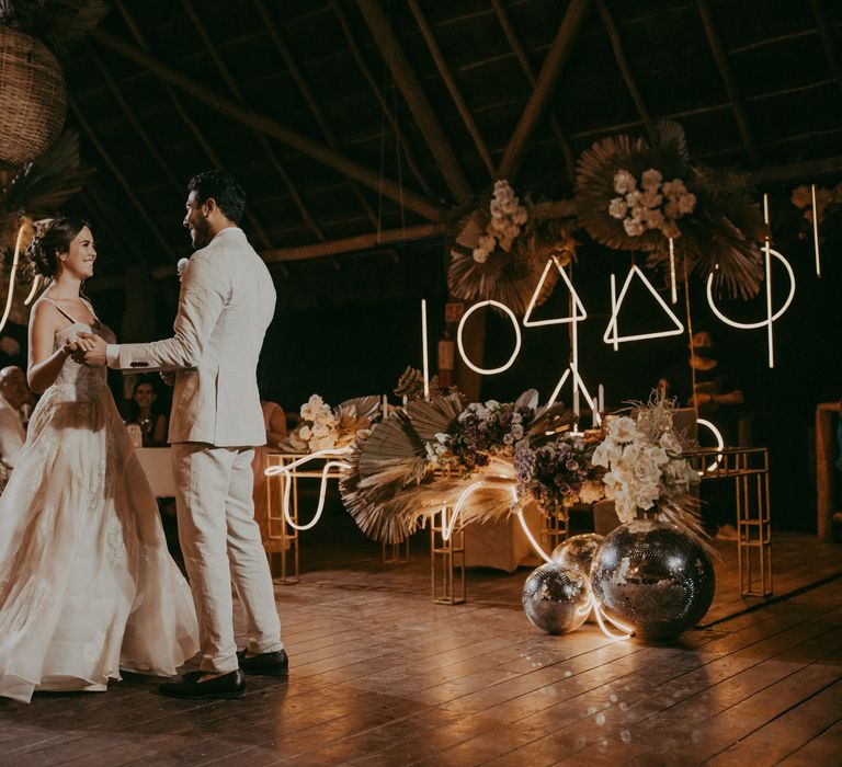 Bride & groom hold hands and look one another in boho chic styling 